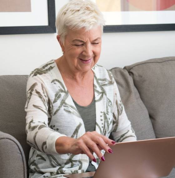 Babyboomer kijkt op laptop